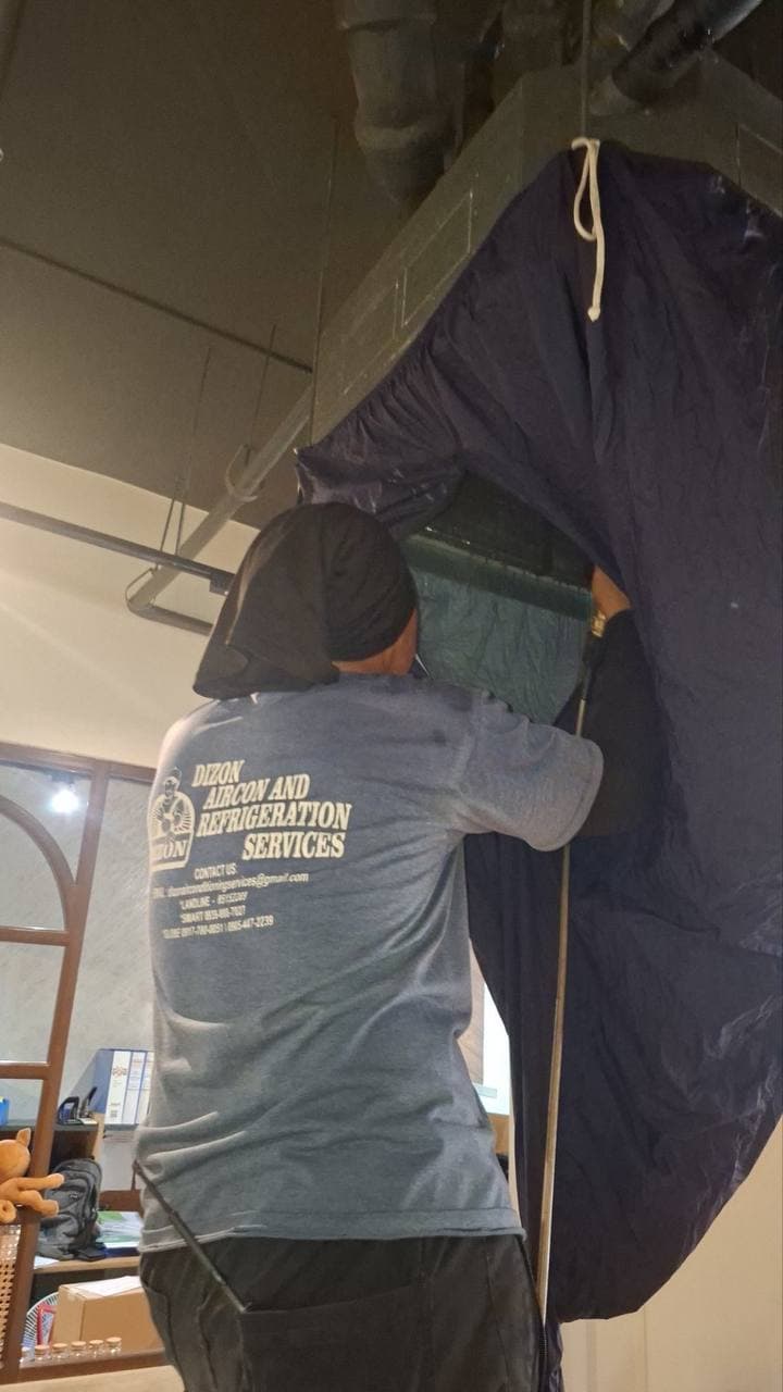Dizon technician deep-cleaning a ceiling-mounted aircon