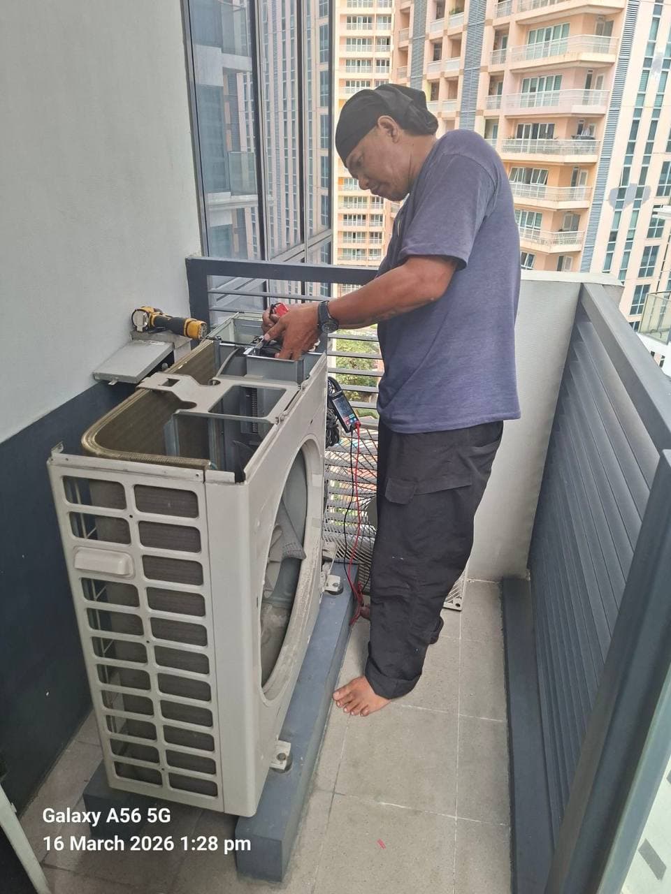 Dizon technician testing an outdoor unit with a multimeter